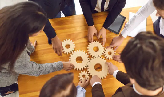 Business team collaborating with interlocking gears during a corporate risk and crisis management strategy meeting