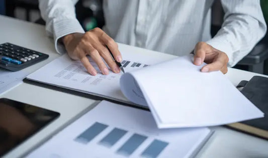 Professional reviewing compliance reports and audit documents for environmental compliance monitoring.