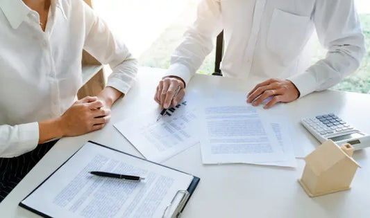 Insurance agent reviewing policy documents and financial information with a client during a professional insurance consultation