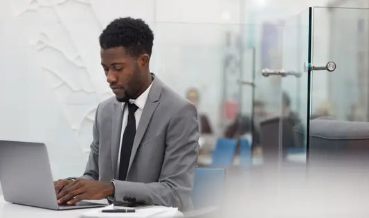 Office administrator working on a laptop in a modern office environment