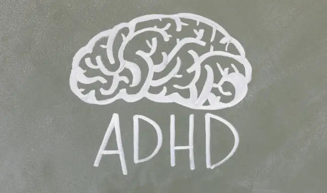 ADHD awareness concept with a chalk-drawn brain illustration and ADHD text on a classroom chalkboard.