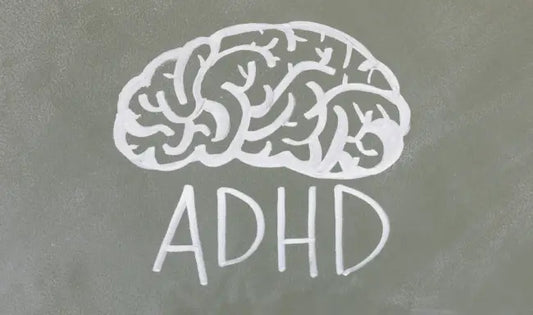 ADHD awareness concept with a chalk-drawn brain illustration and ADHD text on a classroom chalkboard.
