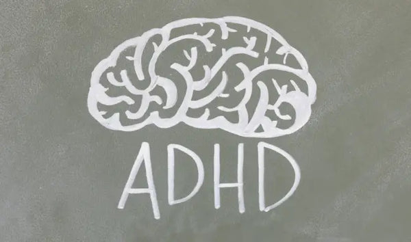 ADHD awareness concept with a chalk-drawn brain illustration and ADHD text on a classroom chalkboard.
