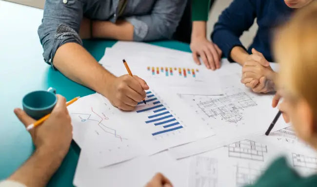 Business team reviewing compliance reports and performance charts during a corporate compliance management strategy meeting.