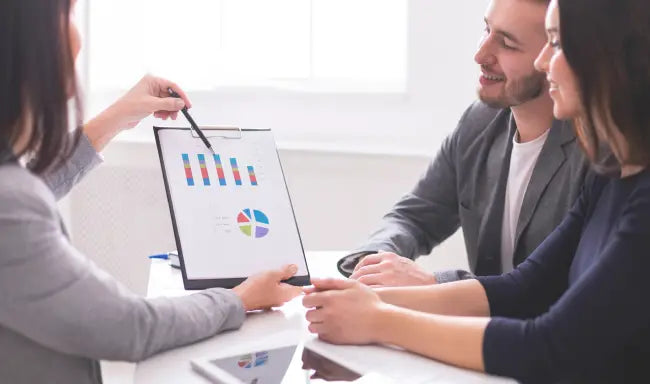Financial advisor presenting investment and financial planning charts to clients during a professional consultation meeting.