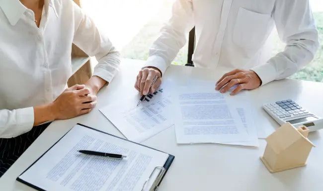 Insurance agent reviewing policy documents and financial information with a client during a professional insurance consultation