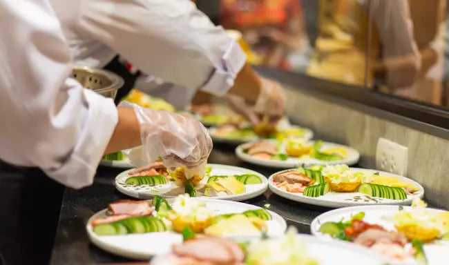 Chef plating meals while following food safety procedures, representing Level 3 food safety supervision in catering and commercial kitchens.