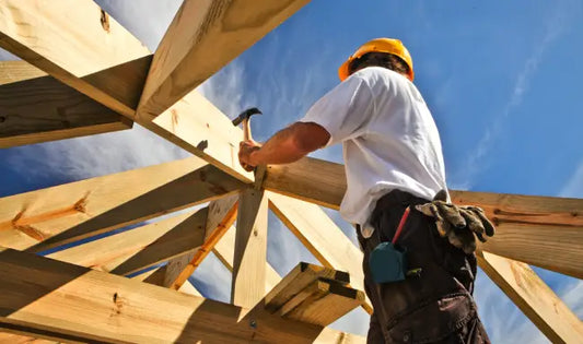 Lone worker safety training with construction worker installing roof timber frame while wearing PPE