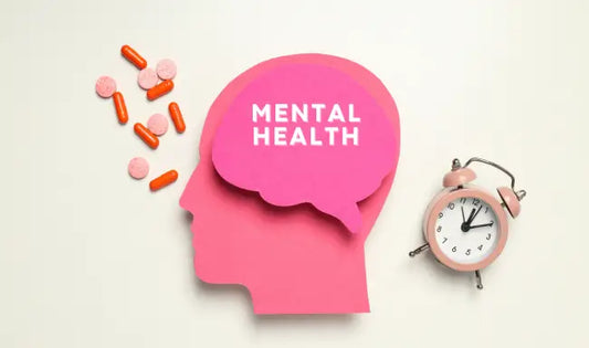 Mental health awareness concept with pink brain silhouette, medication pills, and alarm clock symbolizing mental wellness and treatment.
