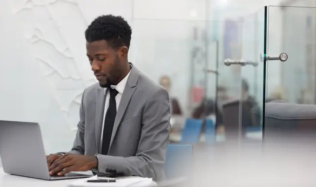 Office administrator working on a laptop in a modern office environment